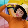 designer Amy Roiland leaning on a graffiti wall wearing Vue DC glasses